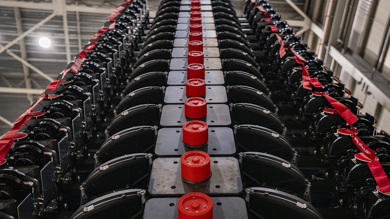 Close-up view of a large industrial machine with rows of black components and red caps, captured from a low angle.