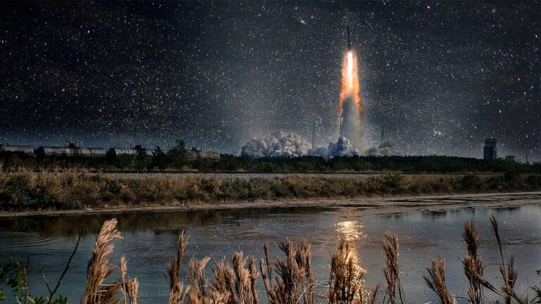 September 2019 AIAA Bulletin A rocket launching into the night sky, leaving a trail of bright orange flames and smoke, with a reflection on the water and starry background.