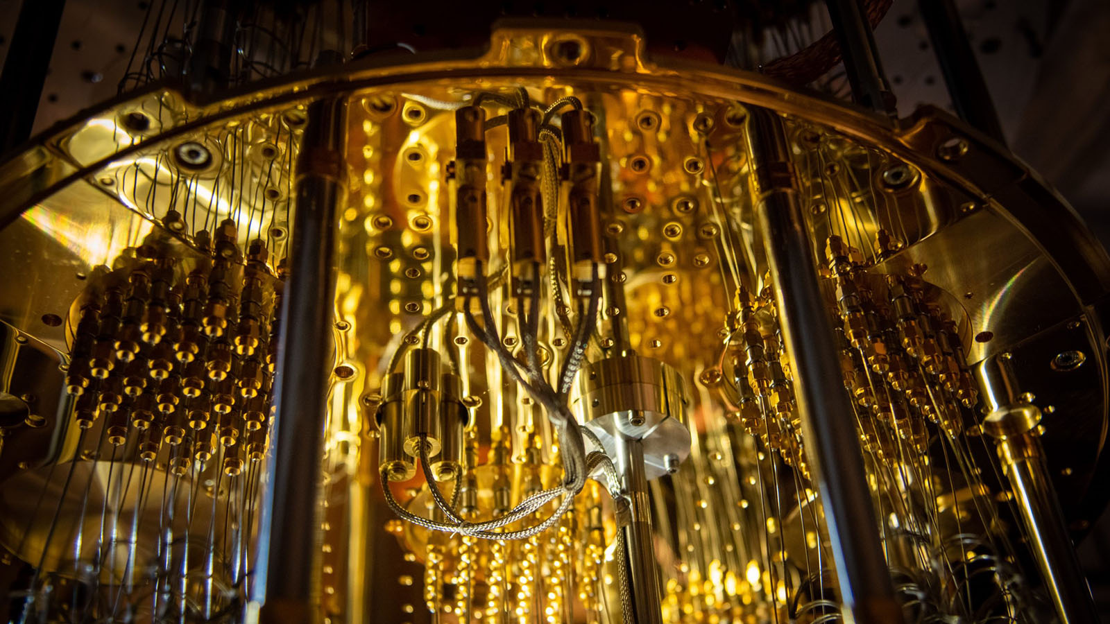 Close-up of a quantum computer's interior showcasing intricate golden wiring, circuits, and components arranged in a complex, symmetrical pattern.