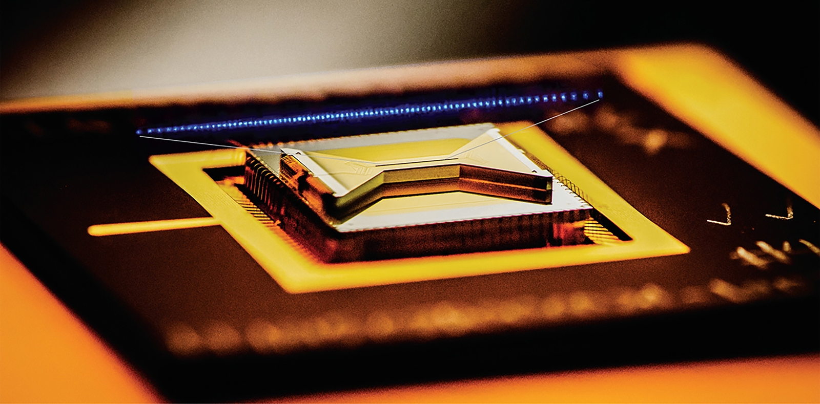 Close-up of a quantum computer processor with intricate gold and metal connections.