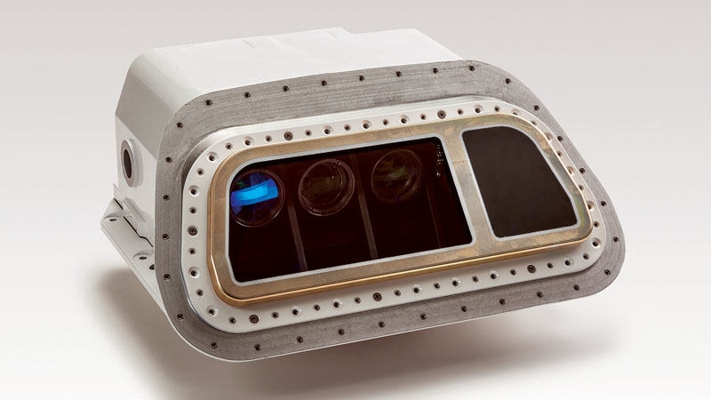 A compact, metallic multi-lens camera module with a rectangular shape and riveted edges on a gray background.